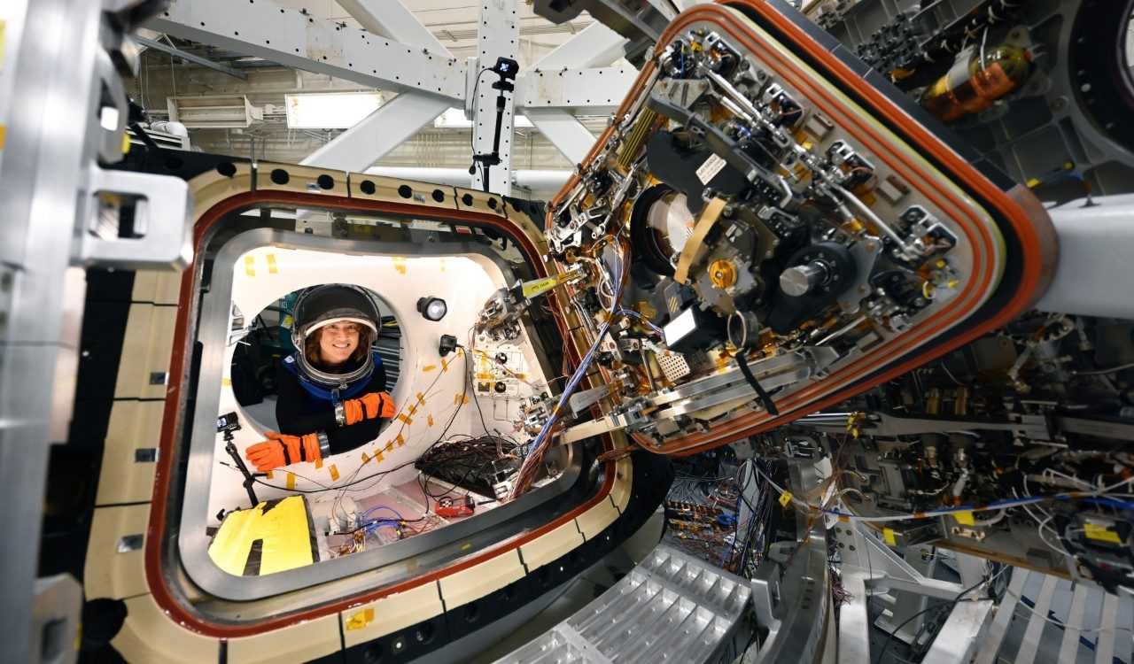 Artemis II mission specialist Christina Koch poses for a photo while testing the hatches on Orion 
